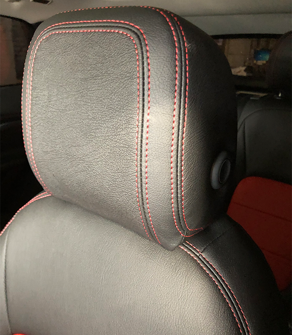 black leather seat back with red stitching
