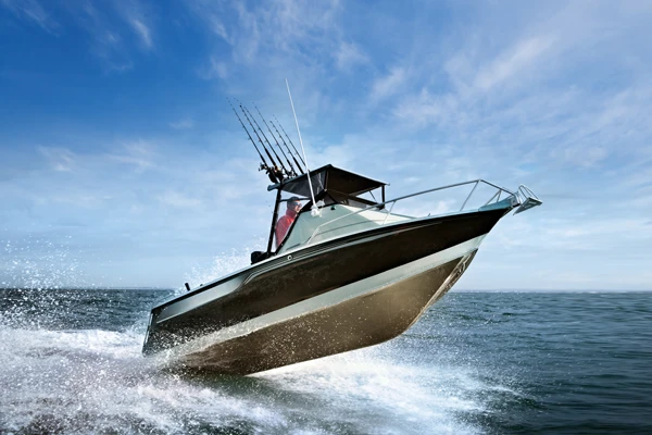 A fishing boat slices through ocean waves